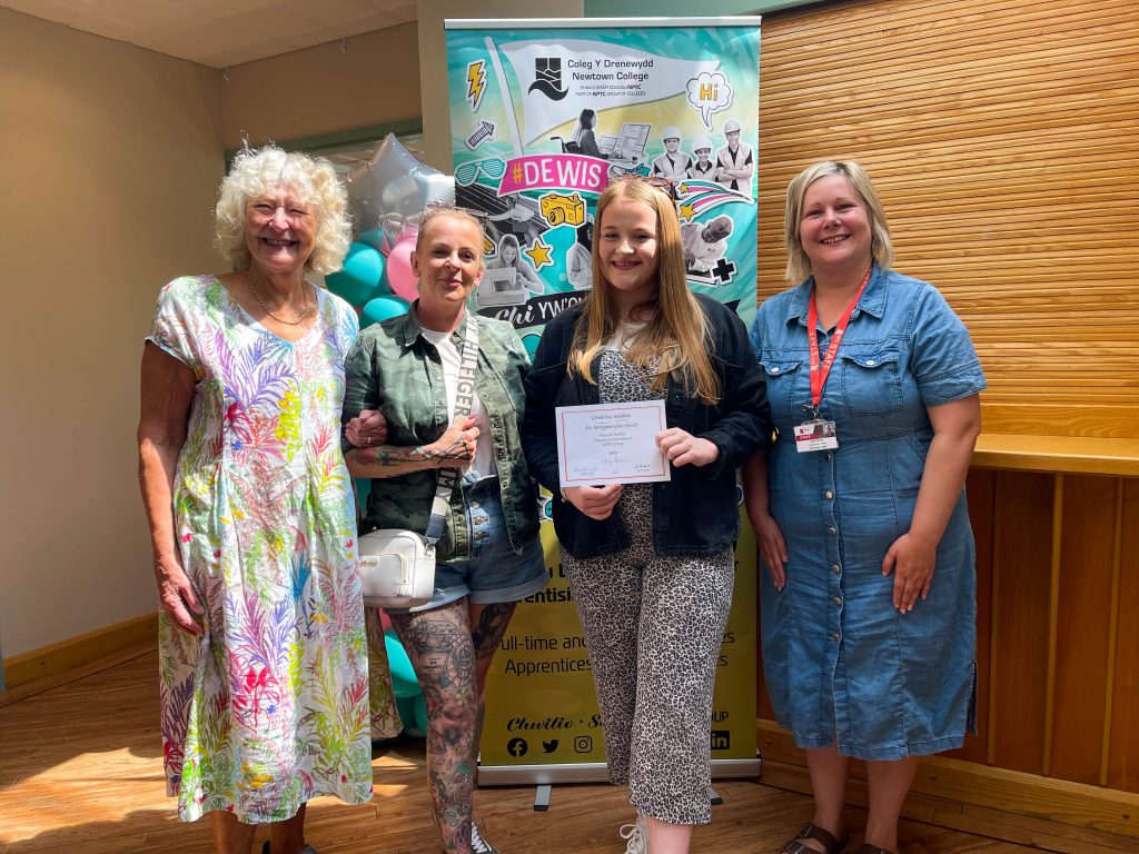 Student Lilly Owen with her award certificate with staff members at Newtown College.