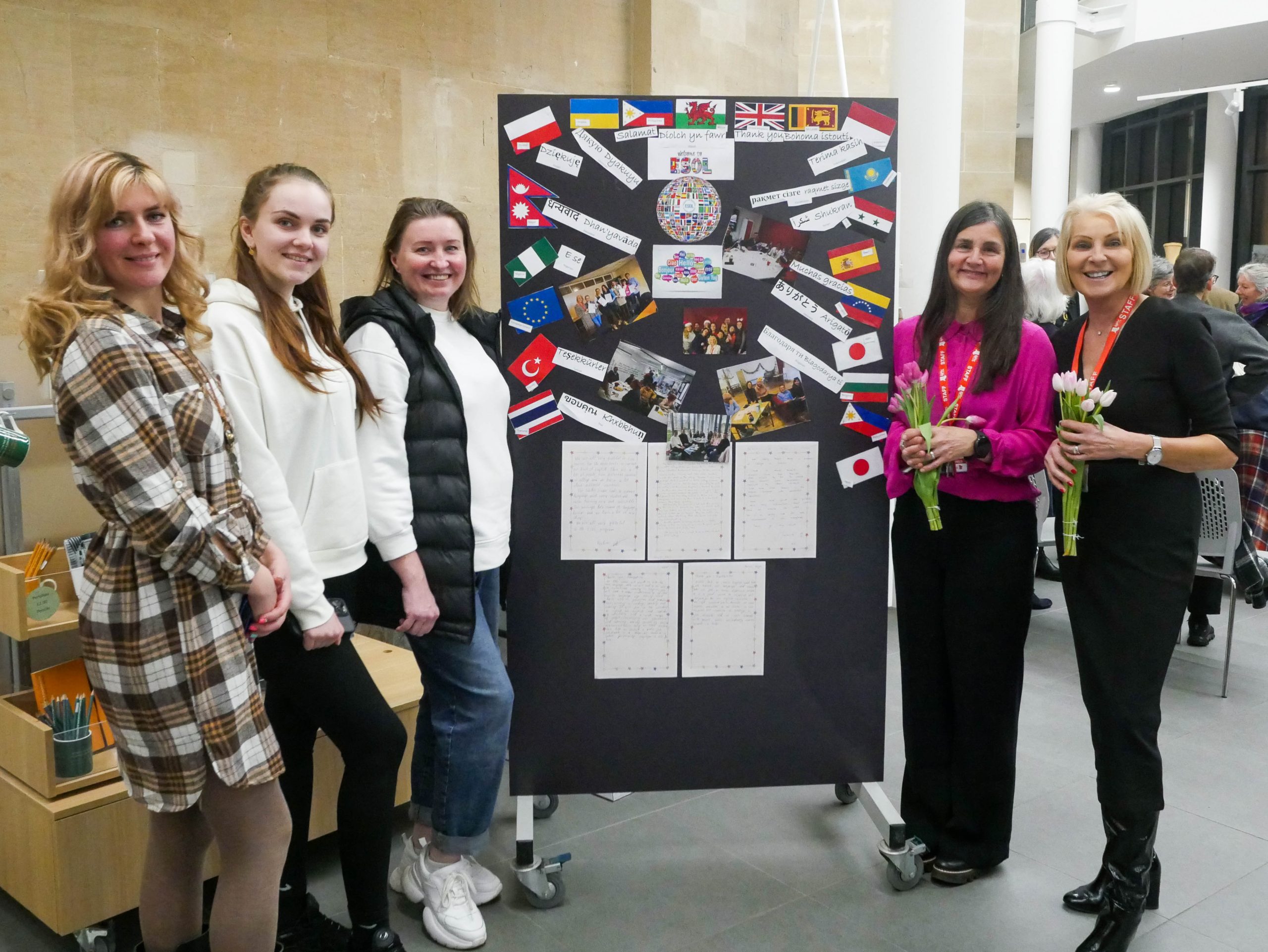 Brecon Beacons ESOL students in front of their diaplsy board at an International Women's Day Event