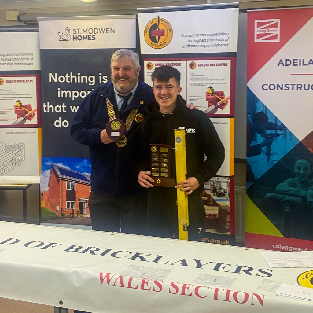 Welsh Senior Bricklaying Champion James Luc Martin with Bill Bowman, President of The Guild of Bricklayers. Two trophies and spirit level being presented.