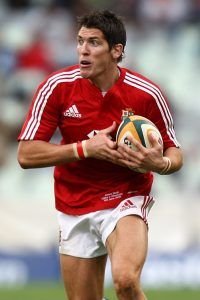 Rugby player James Hook in British and Irish Lions kit running with the ball.