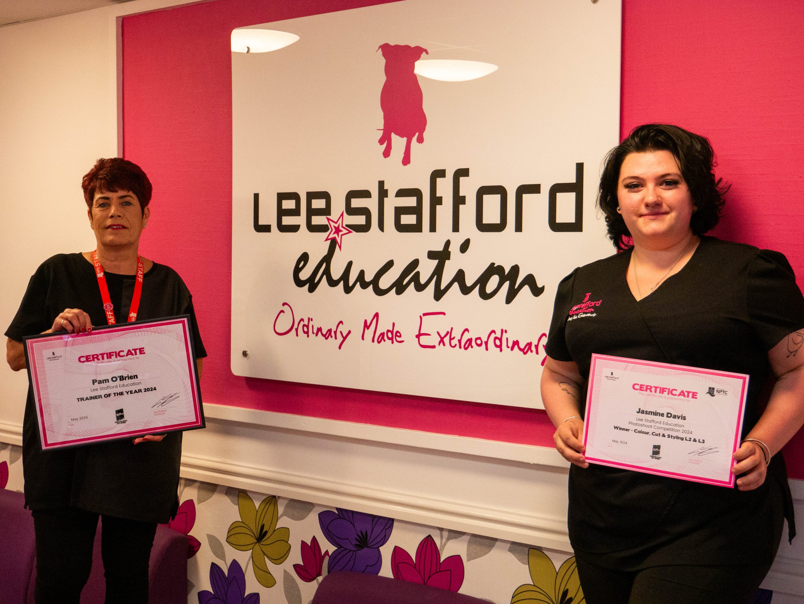 Pamela O’Brien and Jasmine Davies with their awards in front of the Lee Stafford Education sign at Afan College