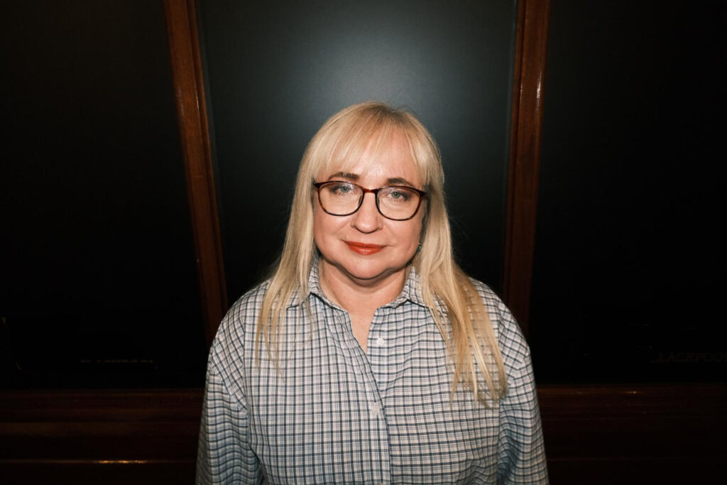 Catherine Lewis in front of a black background