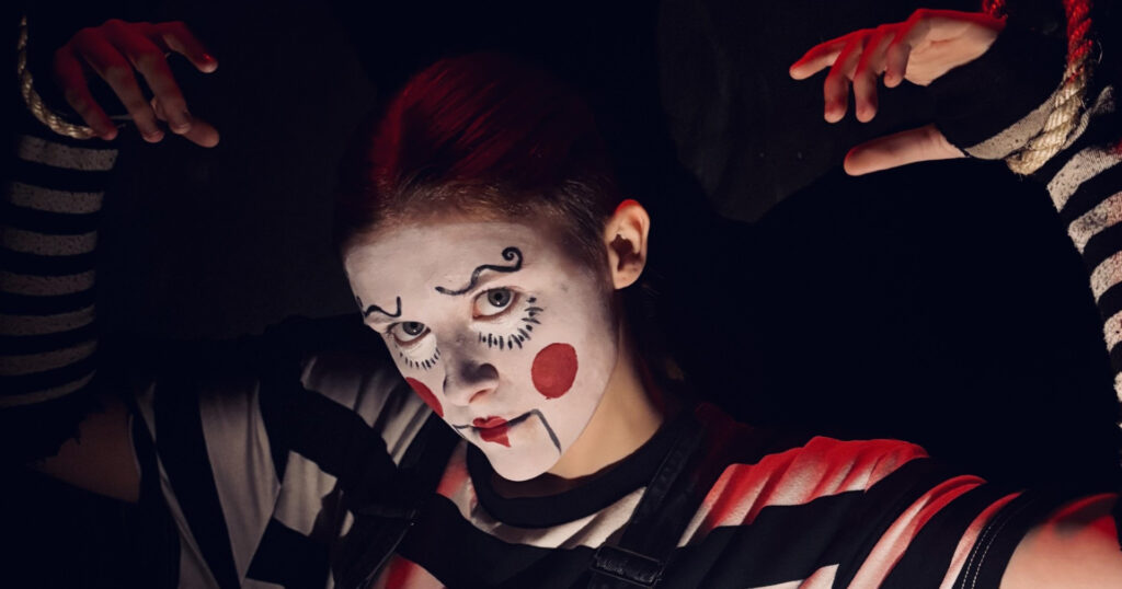 A student performer dressed as a Halloween Clown in the Scare Maze.